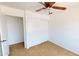 Bright bedroom featuring a ceiling fan, neutral carpet, and a closet with sliding doors at 8541 W Pershing Ave, Peoria, AZ 85381