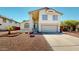 Inviting two-story home featuring a spacious driveway, desert landscaping, and a charming front porch entrance at 8541 W Pershing Ave, Peoria, AZ 85381