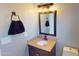 Charming half bathroom featuring a granite vanity and a decorative mirror at 8541 W Pershing Ave, Peoria, AZ 85381