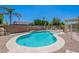 A tranquil backyard pool features a Baja step, lush landscaping, and a security fence at 9345 W Robin Ln, Peoria, AZ 85383