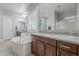 Luxurious primary bathroom with dual vanities, soaking tub, granite countertops, and plantation shutters at 9345 W Robin Ln, Peoria, AZ 85383