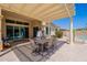 Covered patio with an outdoor dining table, with view of the pool in the backyard at 9345 W Robin Ln, Peoria, AZ 85383