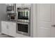 Stainless steel KitchenAid double oven complemented by sleek countertops and ample cabinet storage at 9345 W Robin Ln, Peoria, AZ 85383