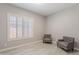 Serene room with neutral walls, light tile flooring, plantation shutters, and two gray upholstered chairs at 9345 W Robin Ln, Peoria, AZ 85383