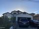 Single-Gathering home with two cars parked in the driveway, desert landscaping, and an attached two-car garage at 10006 N 7Th Pl, Phoenix, AZ 85020