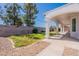 A backyard with a covered patio with pillars, grass, gravel, and a wall at 1062 N Robin Ln, Mesa, AZ 85213