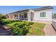A view of the home's back exterior featuring a covered patio, a small yard, and gravel area at 1062 N Robin Ln, Mesa, AZ 85213
