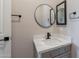 Stylish bathroom featuring a modern vanity with quartz countertop, matte black faucet, and round mirror at 1062 N Robin Ln, Mesa, AZ 85213