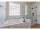 Luxurious bathroom featuring a soaking tub and glass shower at 1062 N Robin Ln, Mesa, AZ 85213