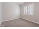 Cozy bedroom featuring neutral tones, plush carpeting, and a large window with shutters for natural light at 1062 N Robin Ln, Mesa, AZ 85213