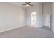Spacious bedroom featuring neutral carpeting, ceiling fan, and ensuite bathroom access at 1062 N Robin Ln, Mesa, AZ 85213