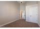 Spacious bedroom featuring neutral tones, plush carpeting, ceiling fan, and an entry doorway to hallway at 1062 N Robin Ln, Mesa, AZ 85213