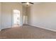 Spacious bedroom featuring neutral tones, plush carpeting, ceiling fan, and an en-suite bathroom for added convenience at 1062 N Robin Ln, Mesa, AZ 85213