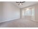 Bright bedroom boasts vaulted ceiling, neutral walls, plush carpet, and large window with shutter for natural light at 1062 N Robin Ln, Mesa, AZ 85213