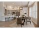 Bright dining area featuring a modern chandelier, a dark wood table, and a view of the kitchen with barstool seating at 1062 N Robin Ln, Mesa, AZ 85213