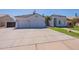 Home exterior featuring a well-kept lawn, two-car garage, and tile roofing, set under a sunny sky at 1062 N Robin Ln, Mesa, AZ 85213
