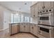 Modern kitchen features stainless steel appliances, white countertops, and light gray cabinets with black hardware at 1062 N Robin Ln, Mesa, AZ 85213