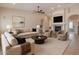 Cozy living room with a fireplace, plush seating, a ceiling fan, and a large painting, perfect for relaxation at 1062 N Robin Ln, Mesa, AZ 85213