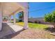 A covered patio with white pillars and a view of the backyard with grass and gravel at 1062 N Robin Ln, Mesa, AZ 85213