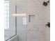 Modern shower with marble tiling, glass enclosure, and matte black fixtures at 1062 N Robin Ln, Mesa, AZ 85213