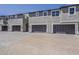 Row of modern townhomes featuring private garages, neutral stucco, and brick driveways at 11300 N Casa Dega Dr # 1019, Surprise, AZ 85388