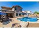 Backyard showcasing a pool, patio with dining, fire pit, and the exterior of the home at 12601 W San Miguel Ave, Litchfield Park, AZ 85340