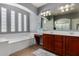 Bright bathroom featuring double sinks, a large bathtub, and ample natural light from the window at 12601 W San Miguel Ave, Litchfield Park, AZ 85340