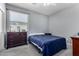Cozy bedroom featuring a bed with blue comforter, light gray walls, and a dresser near a window at 12601 W San Miguel Ave, Litchfield Park, AZ 85340