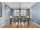 Elegant dining room boasts a modern chandelier, blue accent wall, and seating for six at 12601 W San Miguel Ave, Litchfield Park, AZ 85340