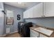 Functional laundry room with modern washer and dryer, cabinets, and sink at 12601 W San Miguel Ave, Litchfield Park, AZ 85340