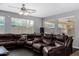 Spacious living room featuring a large brown leather sectional and bright natural light at 12601 W San Miguel Ave, Litchfield Park, AZ 85340