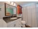 Cozy bathroom with marble countertop, decorative mirror, and shower with curtain at 1406 E Jasper Dr, Chandler, AZ 85225