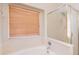 Bright bathroom with a garden tub, shower, and wood blinds at 15128 W Melissa Ln, Surprise, AZ 85374