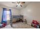 A bedroom with a loft bed, ceiling fan, and large window at 15128 W Melissa Ln, Surprise, AZ 85374