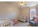 A Bedroom with a crib, couch, and ceiling fan at 15128 W Melissa Ln, Surprise, AZ 85374