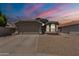 Charming single-story home featuring a two-car garage, gravel landscaping, and neutral-toned exterior paint at 15128 W Melissa Ln, Surprise, AZ 85374