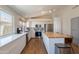 Bright kitchen features white cabinetry, stainless steel appliances, island with seating, and modern fixtures at 15128 W Melissa Ln, Surprise, AZ 85374