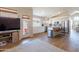 Open concept living room with stainless steel kitchen appliances, white cabinets, and wood flooring at 15128 W Melissa Ln, Surprise, AZ 85374