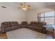 Comfortable living room showcasing reclining sofas, ceiling fan, and a textured area rug at 15128 W Melissa Ln, Surprise, AZ 85374