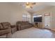Cozy living room showcasing reclining sofas, ceiling fan, and a textured area rug at 15128 W Melissa Ln, Surprise, AZ 85374