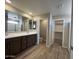 Elegant bathroom featuring a double vanity sink, wooden tile flooring and a separate toilet room at 17493 W Fulton St, Goodyear, AZ 85338