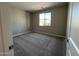 Bedroom boasts plush carpeting, a large window, and neutral paint, offering a cozy space at 17493 W Fulton St, Goodyear, AZ 85338