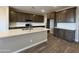 Spacious kitchen featuring white backsplash, wooden cabinetry, a large island and hard surface floors at 17493 W Fulton St, Goodyear, AZ 85338