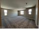 Spacious living room featuring neutral walls, carpet flooring and ample natural light from the windows at 17493 W Fulton St, Goodyear, AZ 85338