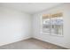 Sunlit bedroom with neutral carpet and window overlooking neighborhood at 17778 W Turquoise Ave, Waddell, AZ 85355