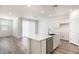 Contemporary kitchen has stainless appliances, an island with sink, and wood-look floors at 17778 W Turquoise Ave, Waddell, AZ 85355