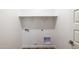 Functional laundry room with shelf, white walls, and access points at 17778 W Turquoise Ave, Waddell, AZ 85355