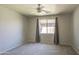 Neutral bedroom with plush carpet, window, and ceiling fan provides comfortable space at 1831 S Hudson Dr, Chandler, AZ 85286