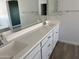 Bright bathroom featuring double sinks, white cabinets, and tile flooring at 18361 W Jessie Ln, Surprise, AZ 85387