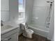 Bright bathroom featuring shower and bath, toilet, sink, and a large window at 18361 W Jessie Ln, Surprise, AZ 85387